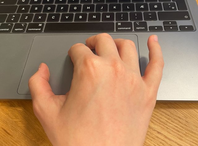 Billede: Hånd på MacBooks pegefelt taget af avXperten